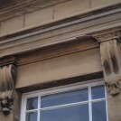 Photo:Detail of carved scrollwork atop main windows